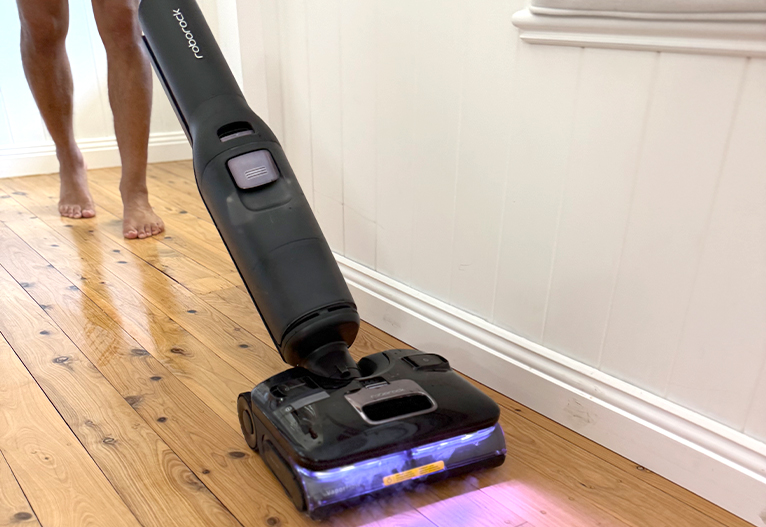 Person using the Roborock F25 Ultra wet dry vacuum on floorboards.