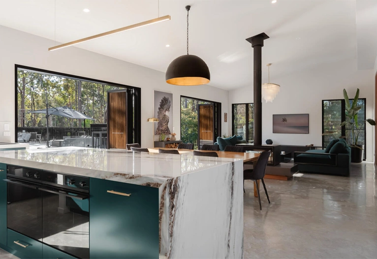 Modern kitchen and living room with teal cabinetry.
