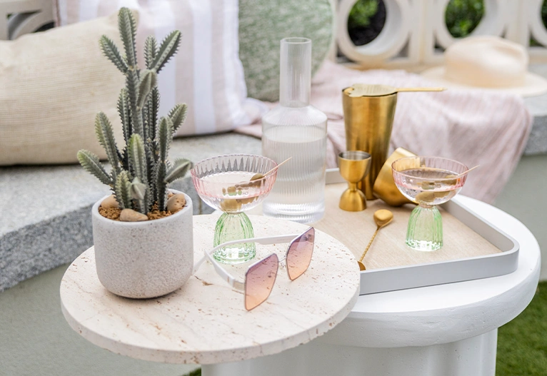 Curved outdoor coffee table with curved accessories on top.