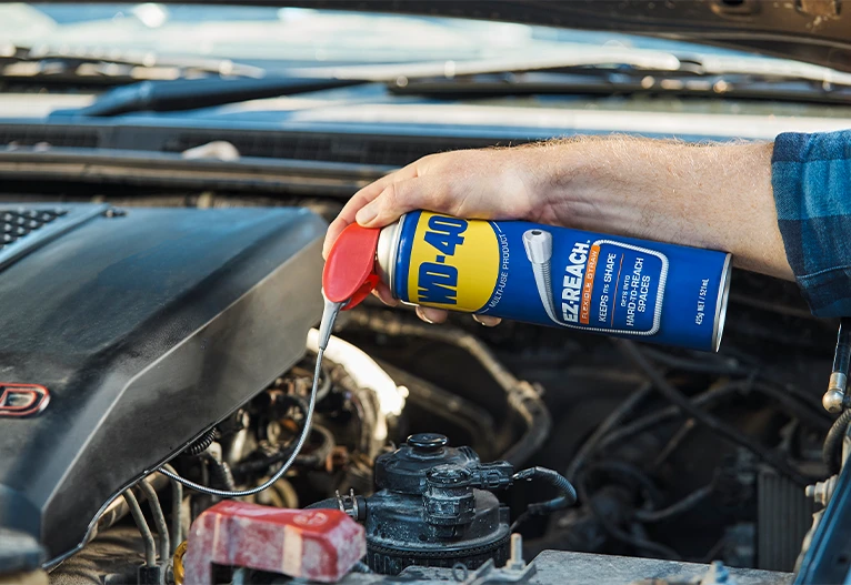 Person using WD-40 on their car.